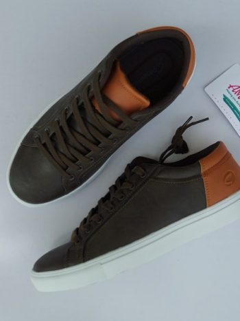 Brown sneaker with white sole and orange edge